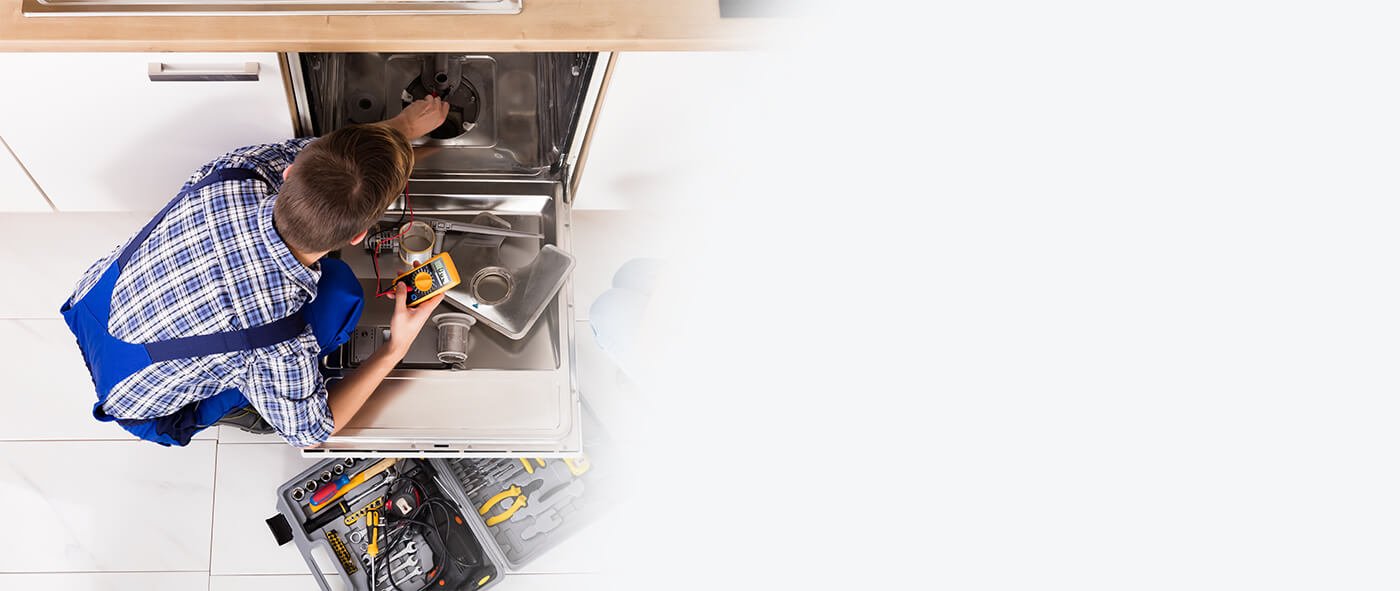 appliance repair technician working on dishwasher