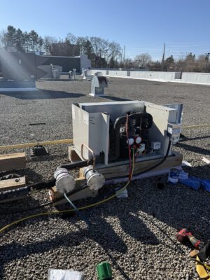 Open rooftop commercial refrigeration condensing unit with gauges and service hoses