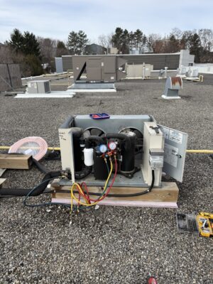 Rooftop commercial refrigeration condensing unit connected to service gauges