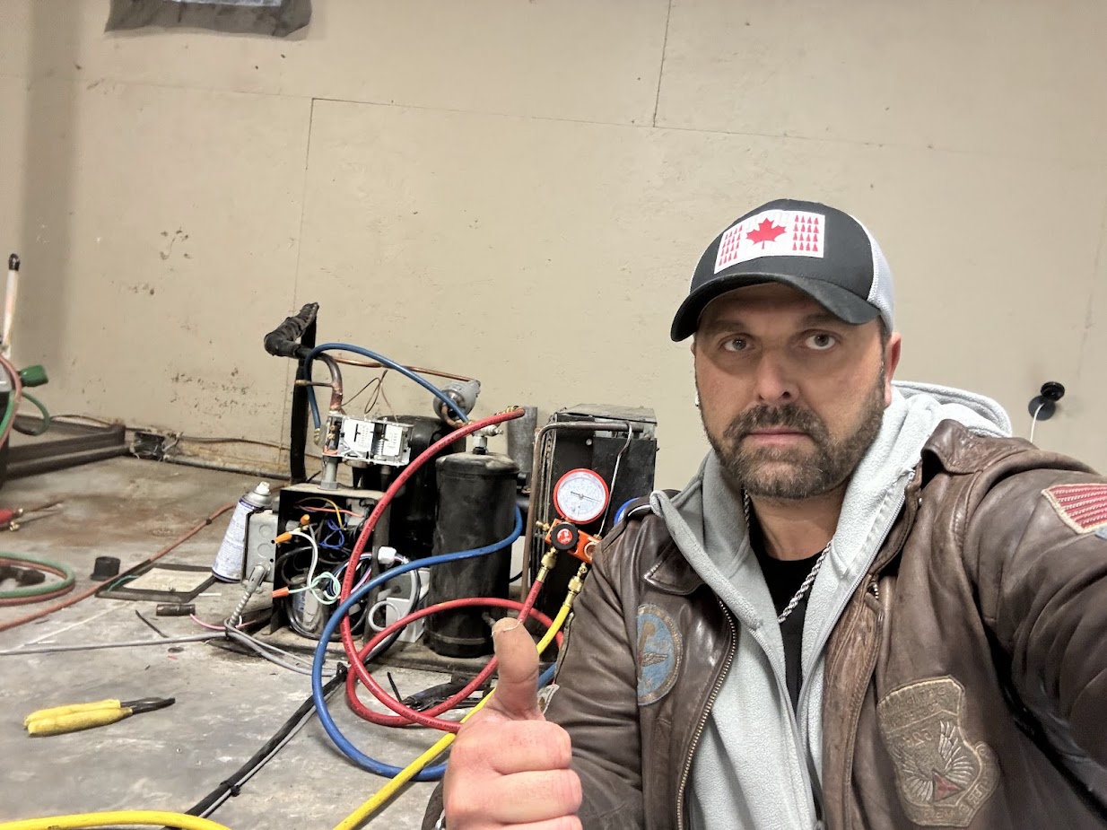 CooperFix refrigeration technician using service gauges