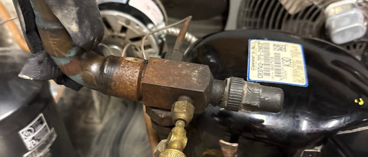 Commercial refrigeration service valve connected to a refrigerant service hose