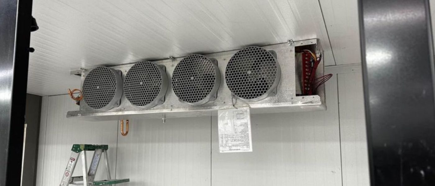 Evaporator unit inside a commercial walk-in cooler during a service visit