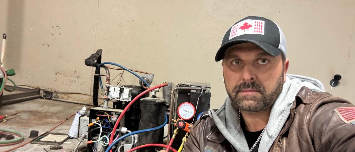 CooperFix refrigeration technician using service gauges