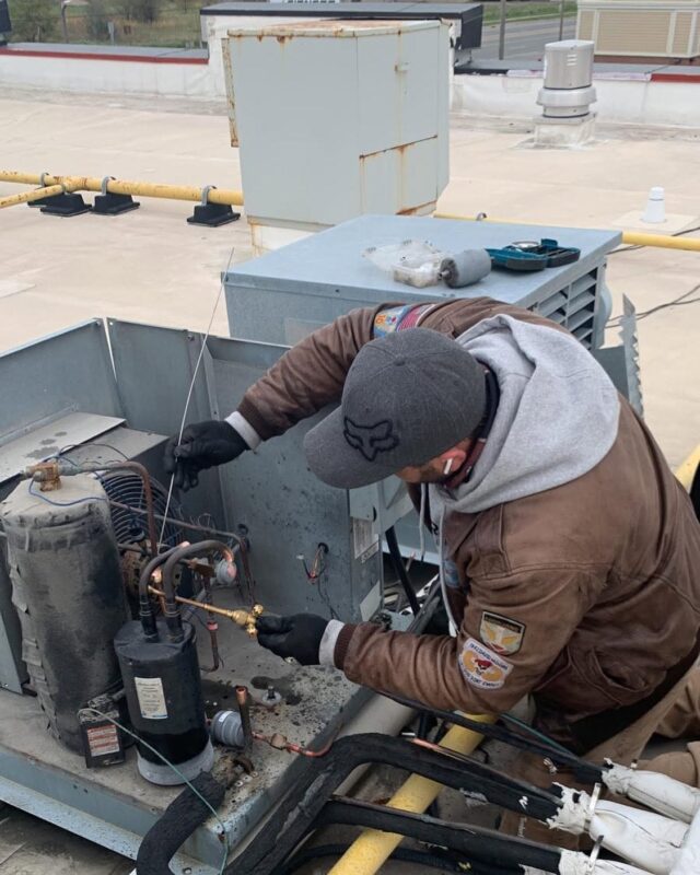 CooperFix technician servicing a rooftop refrigeration unit