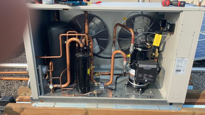 Condensing unit of a commercial walk-in freezer with the panel removed