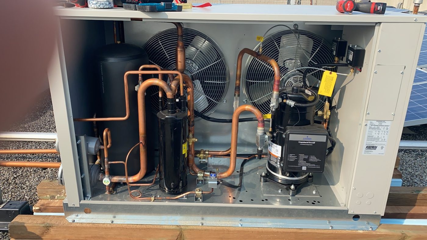 Condensing unit of a commercial walk-in freezer with the panel removed