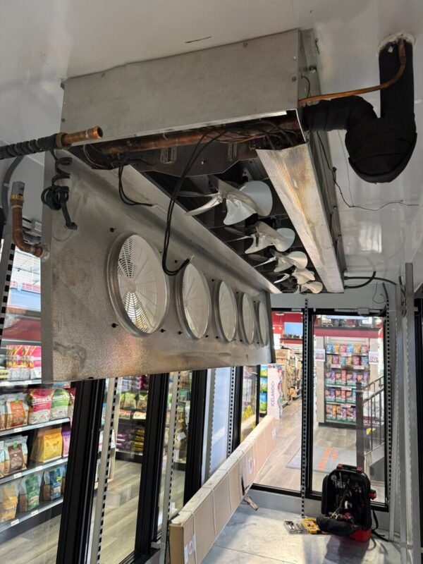Evaporators mounted above commercial display cases in a retail store, photographed on a CooperFix call