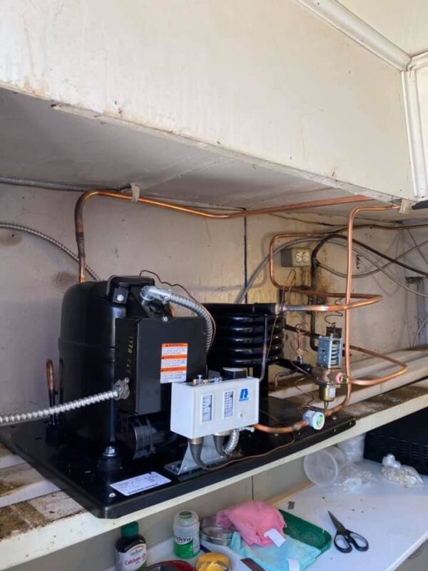 Condensing section of a commercial freezer cabinet opened for service by CooperFix