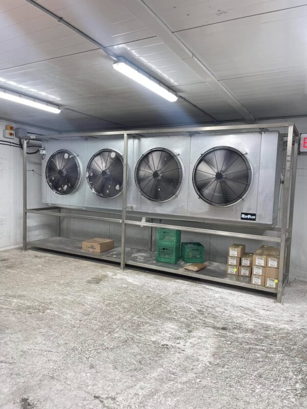 Large multi-fan evaporator bank serving a shared walk-in refrigeration system, photographed by CooperFix