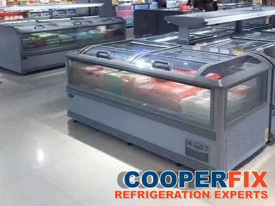 Bank of commercial island freezer cases in a supermarket.