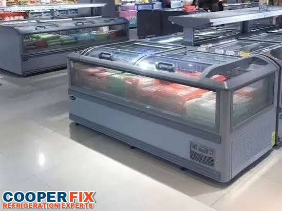 Bank of commercial island freezer cases in a supermarket.