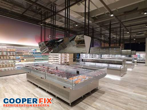 Wide commercial island freezer installation in a supermarket.